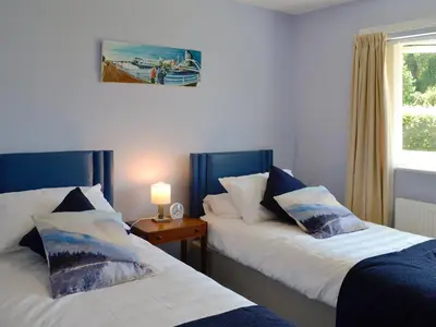 two beds in a room with a window at Rotherwood in Portinscale