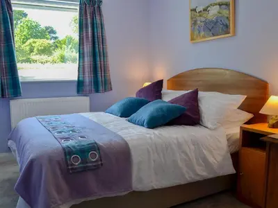 a bedroom with a bed with pillows and a window at Rotherwood in Portinscale