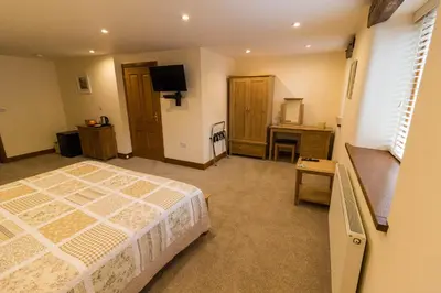 a bedroom with a bed and a desk and a television at Lords Seat Bed & Breakfast in Keswick