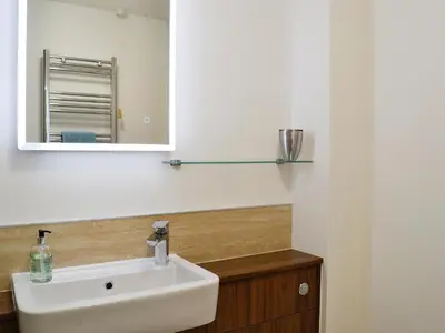 a bathroom with a sink and a mirror at Little Cottage in Wigtown