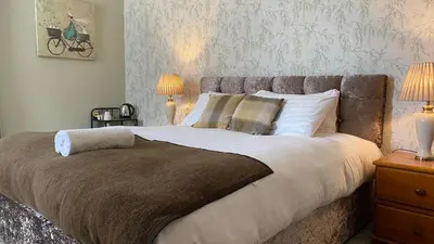 a bedroom with a large bed with two lamps at Ernespie House Hotel in Castle Douglas