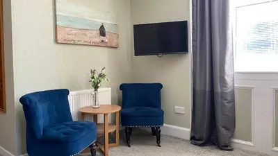 two blue chairs and a table and a tv at Ernespie House Hotel in Castle Douglas