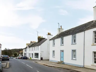 a row of white houses on a street at Callander's High Street in Gatehouse of Fleet