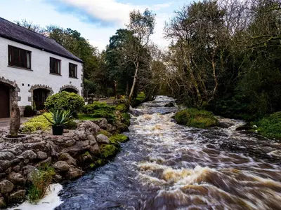a river in front of a house and a building at Anvil in Dalbeattie