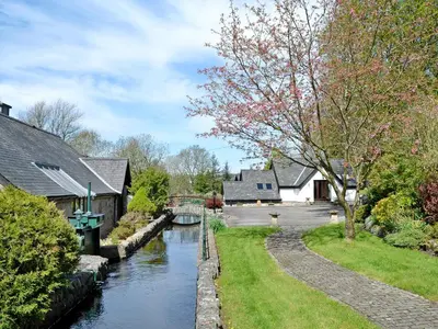 a canal in a village with houses at Waterwheel in Dalbeattie