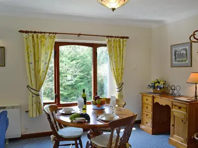 a dining room with a table and a window at Waterwheel in Dalbeattie