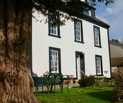a white house with a tree in front of it at Craigmount in Wigtown