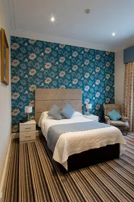 a bedroom with a bed and a floral wall at South Beach Hotel in Troon