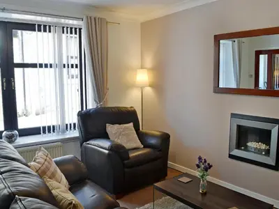 a living room with a couch and a chair at Summerlea Cottage in Moffat