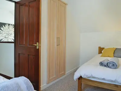 a bedroom with a bed and a wooden door at Summerlea Cottage in Moffat