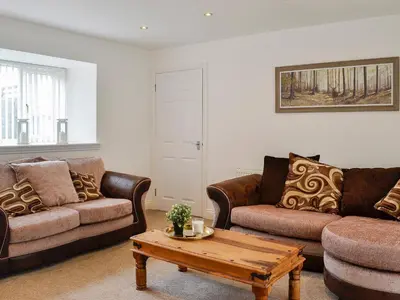 a living room with two couches and a coffee table at Kirroughtree Steading 1 - Uk5859 in Newton Stewart