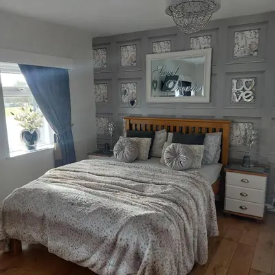 a bedroom with a large bed with gray walls at Broadlea of Robgill Country Cottage bed and breakfast in Ecclefechan