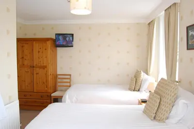 a bedroom with two beds and a window at Beckside Guest House Keswick in Keswick