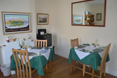 a dining room with two tables and a mirror at Beckside Guest House Keswick in Keswick