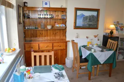 a kitchen with a table and a dining room at Beckside Guest House Keswick in Keswick