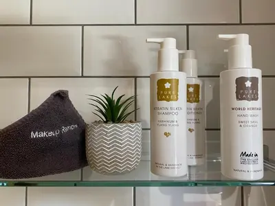 a shelf with three bottles of hair products on it at Goodwin House in Keswick