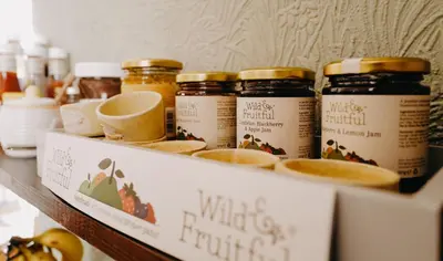a shelf with various jars of honey on it at Goodwin House in Keswick