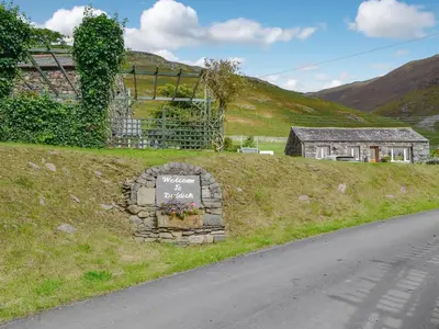 a sign sitting on the side of a road at Shepherds Bield - Uk1349 in Threlkeld