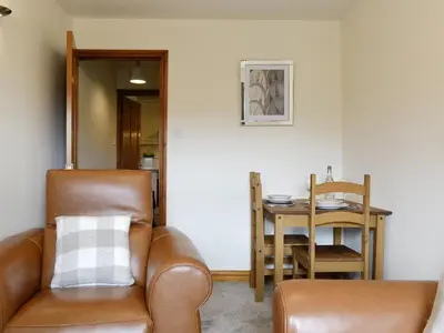 a living room with a leather chair and a table at Shepherds Bield - Uk1349 in Threlkeld
