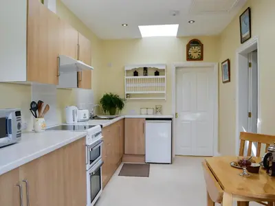 a kitchen with white appliances and a wooden table at Wee Cordorcan - Uk5890 in Bargrennan