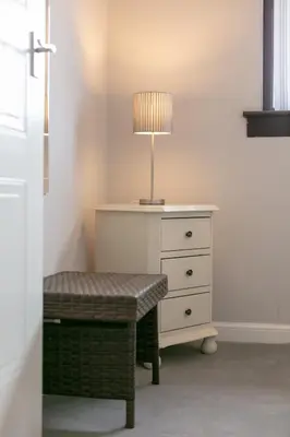 a lamp sitting on top of a dresser next to a drawer at The Huntington - Donnini Apartments in Ayr