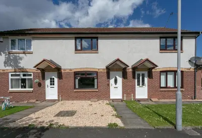 a brick house with white doors on a street at The Huntington - Donnini Apartments in Ayr