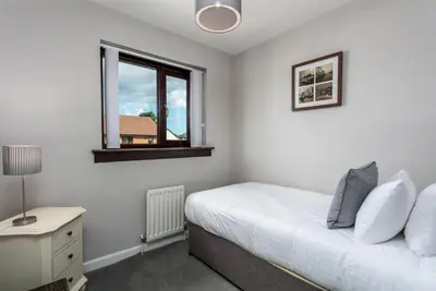 a bedroom with a bed and a window at The Huntington - Donnini Apartments in Ayr