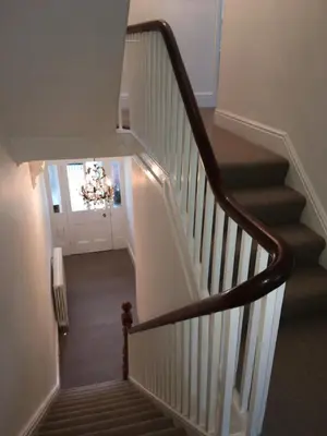a hallway with a staircase with a chandelier at Raymonds in Douglas