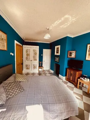 a bedroom with a large bed with blue walls at Fitz House in Keswick