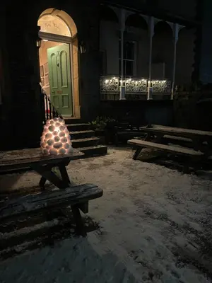a vase sitting on a bench in front of a door at Fitz House in Keswick
