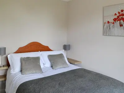 a white bed with two pillows in a bedroom at Brae Cottage in Kelton