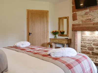 a bedroom with a bed with two towels on it at Holmegarth in Plumbland