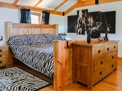 a bedroom with a bed and a wooden dresser at Swallow Cottage - Ukc3427 in Dalston