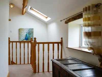 a room with a staircase with a skylight and a window at Farm Cottage in Cleator