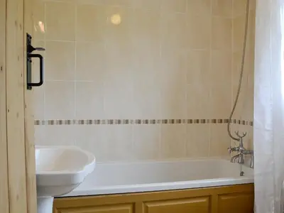 a bathroom with a white tub and a sink at Rose Cottage in Cleator