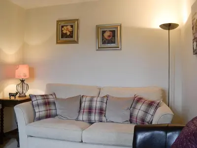 a living room with a couch with plaid pillows at Rose Cottage in Cleator