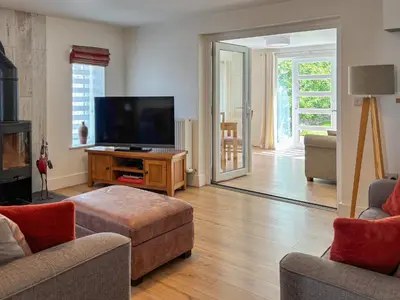 a living room with a flat screen tv and a couch at Townend Cottage in Aikton