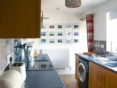 a kitchen with a washer and dryer on a counter at Townend Cottage in Aikton