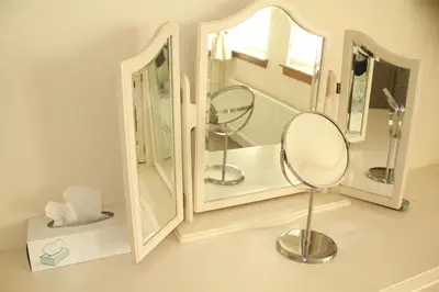 a bathroom with two mirrors and a chair in it at Abbots Way in Ayr