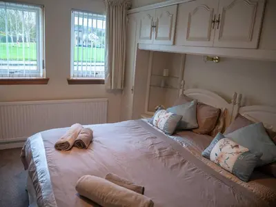 a bedroom with a large bed with towels on it at Abbots Way in Ayr