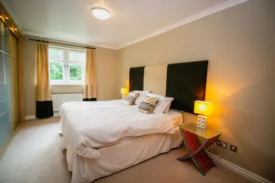 a bedroom with a large bed and two lamps at Turnberry Apartments in Turnberry