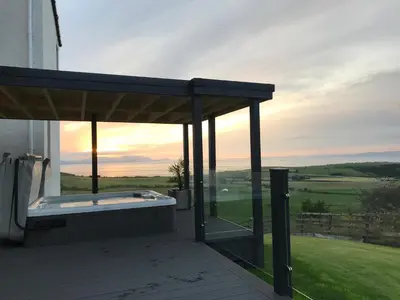 a hot tub under a pavilion on a house at Carrick Hills Cosy Croft STL SA-00137-F in Dunure