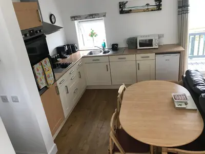 a kitchen with a wooden table and a kitchen with a sink at Carrick Hills Cosy Croft STL SA-00137-F in Dunure