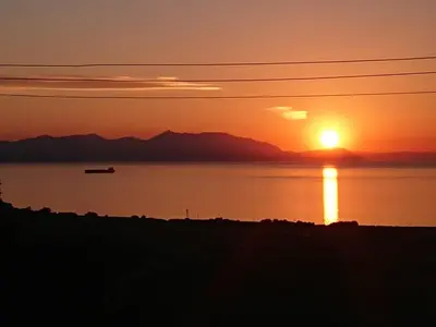 a sunset over a body of water with a boat at Carrick Hills Cosy Croft STL SA-00137-F in Dunure