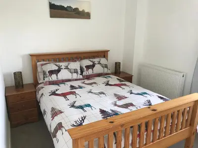 a bedroom with a bed with a quilt with deer on it at Carrick Hills Cosy Croft STL SA-00137-F in Dunure