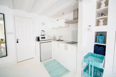 a kitchen with white cabinets and a blue stool at The Retreat Studio in Carlisle