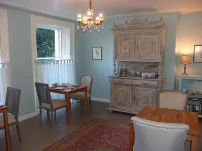 a dining room with a table and a large wooden cabinet at Osborne House B&B Workington in Workington