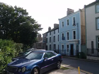 a blue car parked on the side of a street at Osborne House B&B Workington in Workington