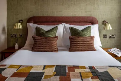 a large white bed with pillows on top of it at Royal Oak at Keswick in Keswick