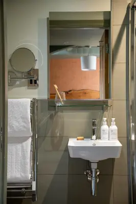 a bathroom with a sink and a mirror and towels at Royal Oak at Keswick in Keswick